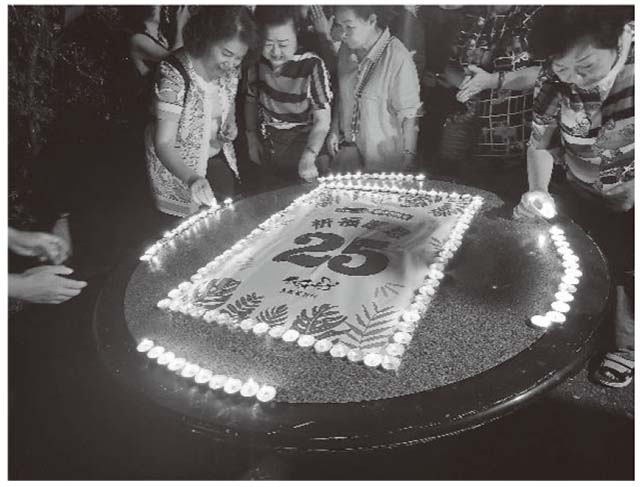 「25年を祝ってろうそくの灯を置くボランティアのお母さんたち」の画像